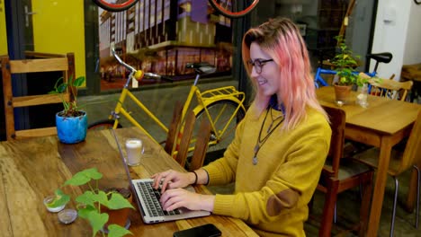 mujer joven usando una computadora portátil en el café 4k