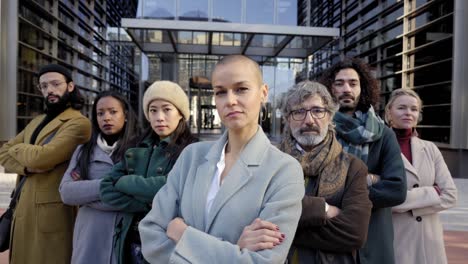 a group of business people crossing arms from a company led by an empowered woman. looking at camera portrait of a group of coworkers of diverse races and ages.