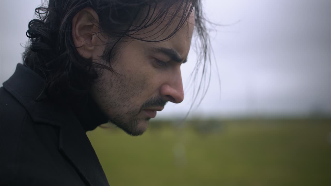 A sad man standing in cemetery for funeral
