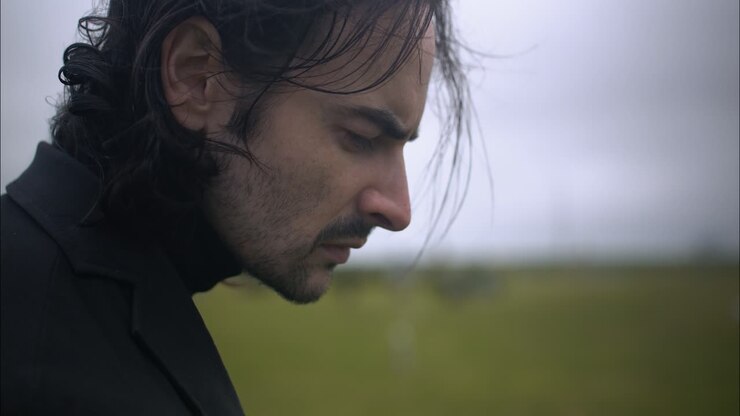 A sad man standing in cemetery for funeral
