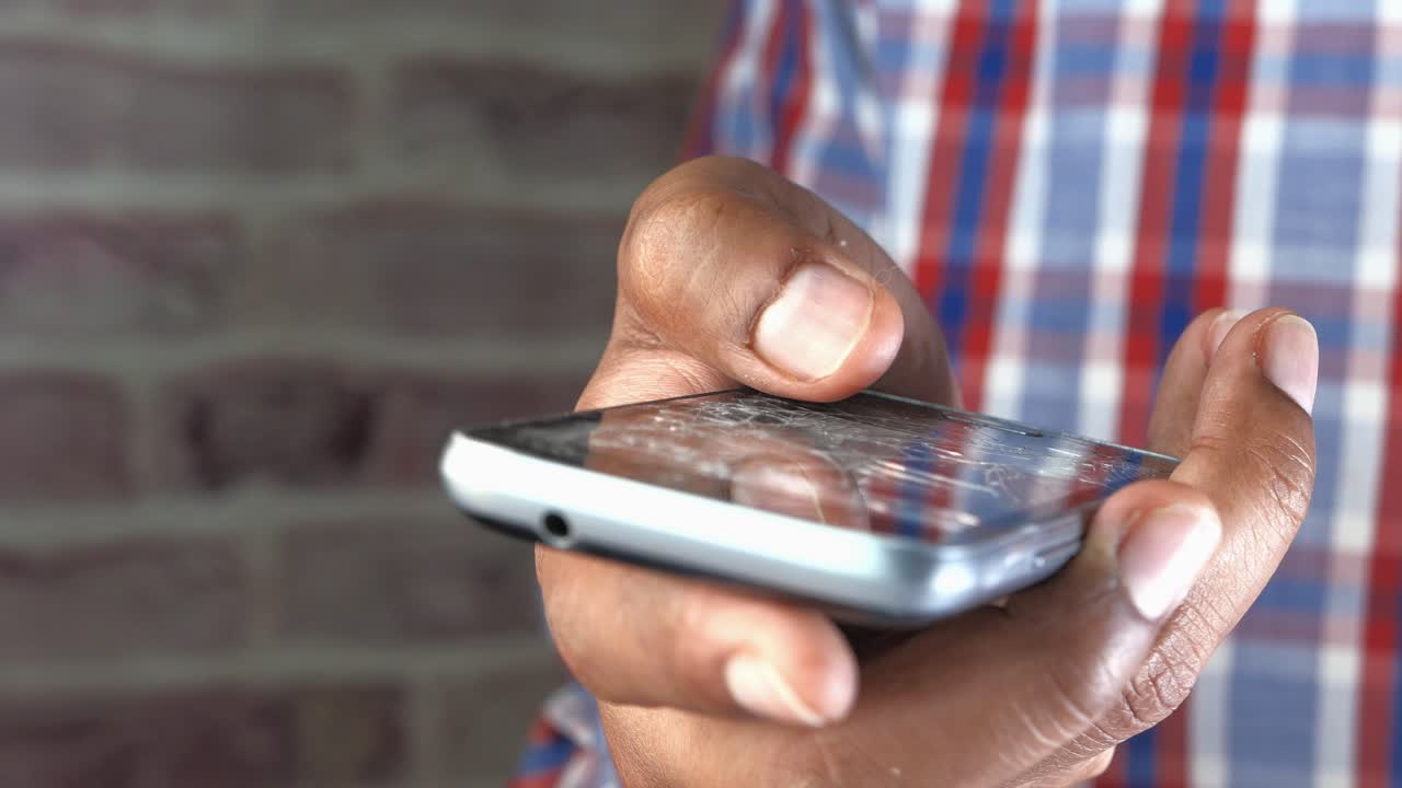persona con un teléfono inteligente agrietado