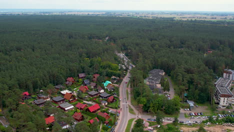 Coches-Circulando-Por-La-Carretera-A-Lo-Largo-De-Los-Hoteles,-Apartamentos-Y-Bosques-En-Stegna,-Polonia.