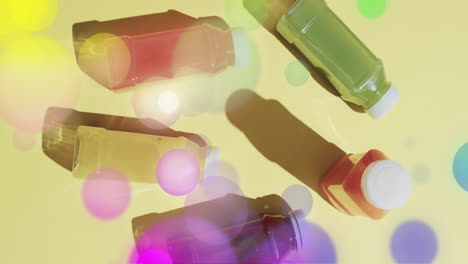 composición de manchas de luz sobre botellas con jugos de frutas sobre fondo amarillo