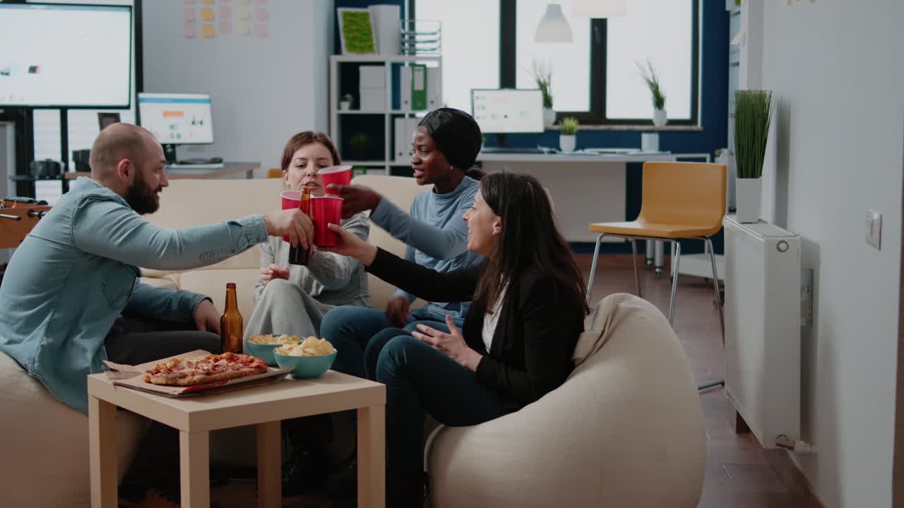 Workmates cheers with beer and alcoholic beverage