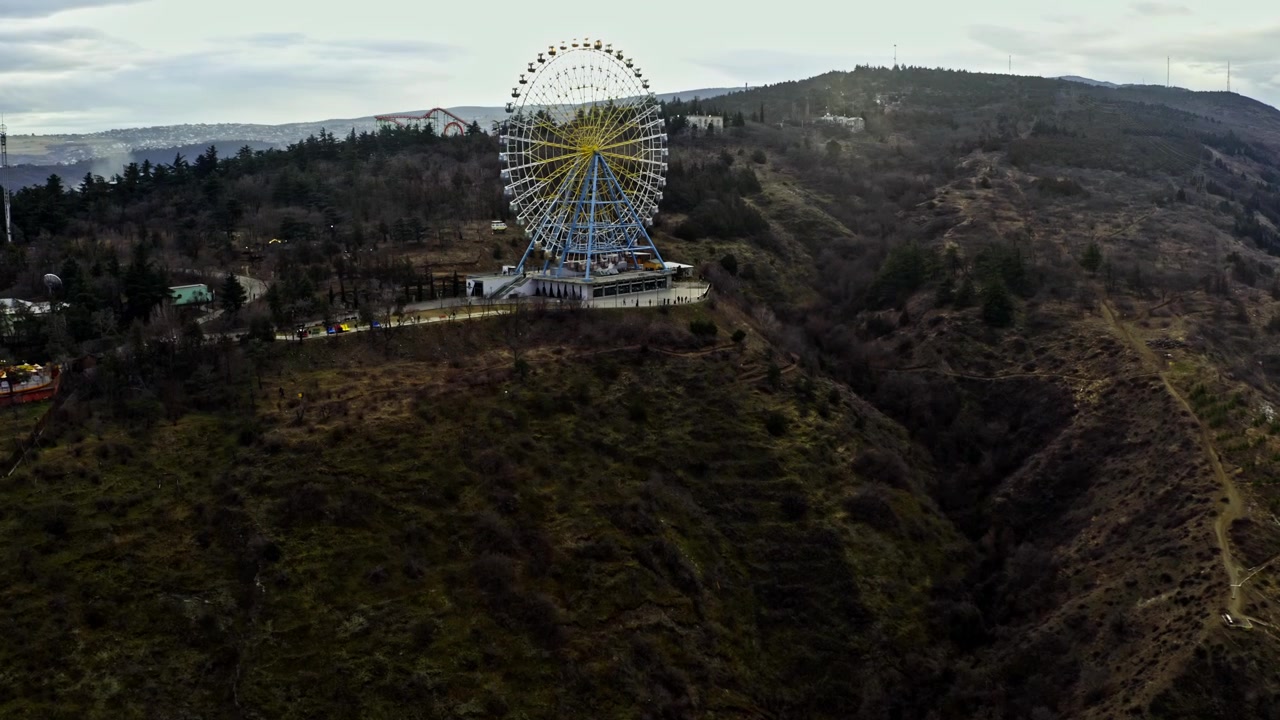 Giro sulla ruota panoramica al Parco Mtatsminda sulla cima della montagna a Tbilisi, Georgia. Ripresa con drone.