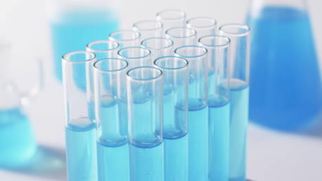 video of glass laboratory test tubes with blue liquid with copy space on white background