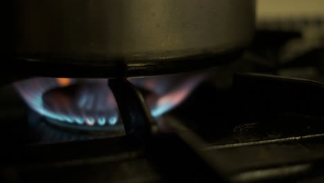 blue flame of a gas oven or stove burning under a pot or pan