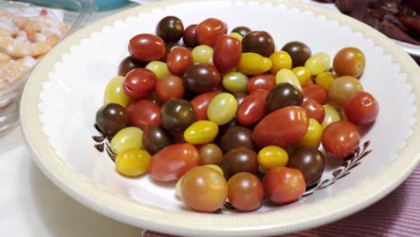 Una-Mano-Agarra-Un-Tomate-Cherry-De-Un-Tazón-De-Tomates-Cherry-Mixtos-En-4k