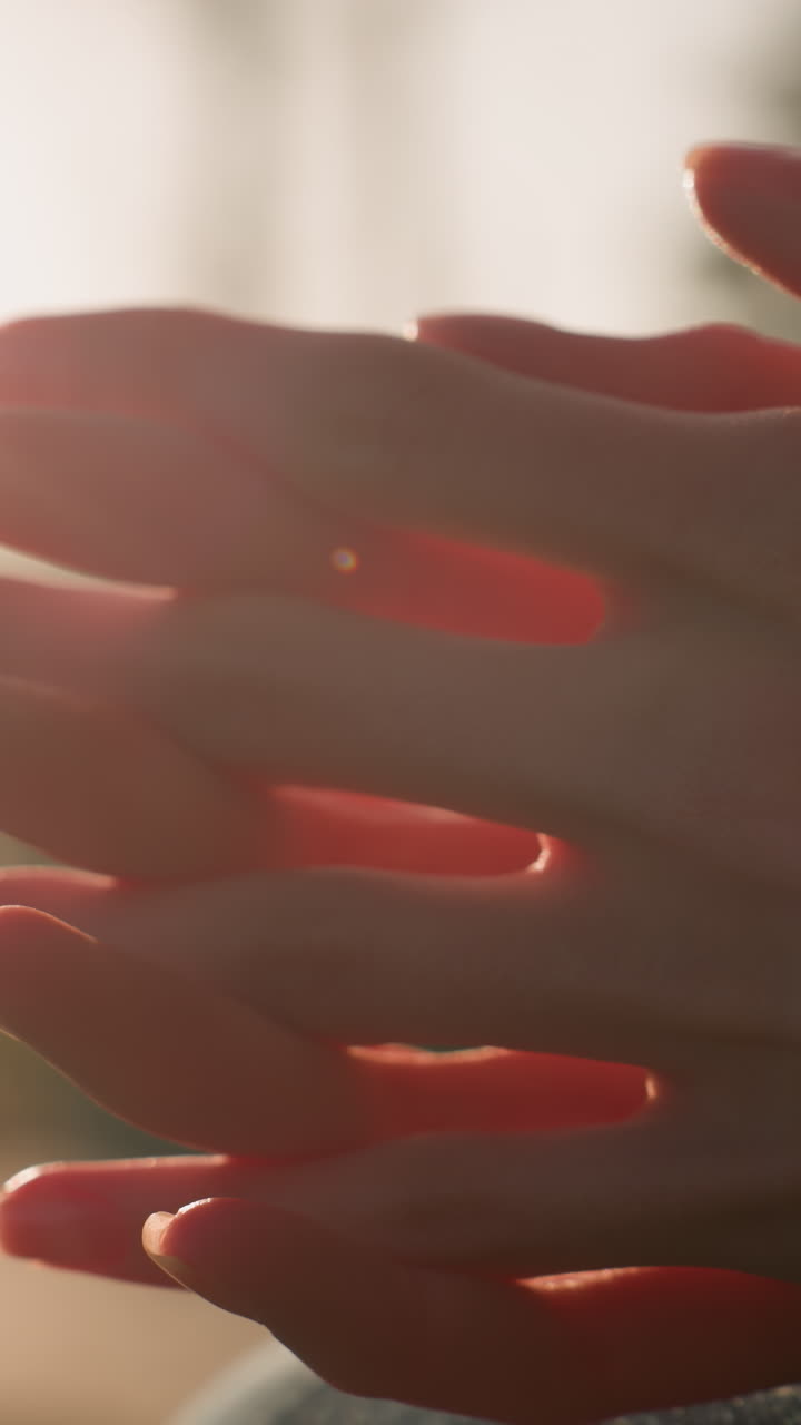 toma de primer plano de manos frotándose en un gesto de pensamiento profundo o contemplación. la luz cálida crea una atmósfera suave e introspectiva, enfatizando la profundidad emocional y el enfoque del momento