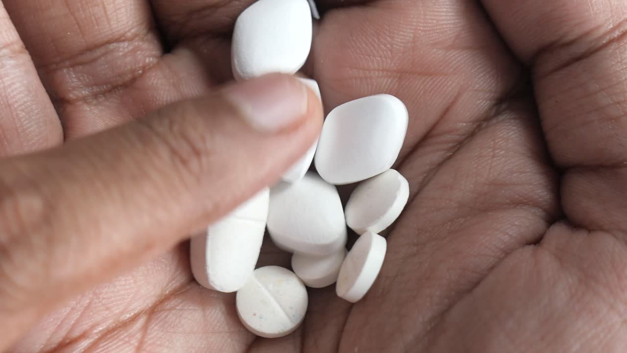 mano con varias pastillas blancas