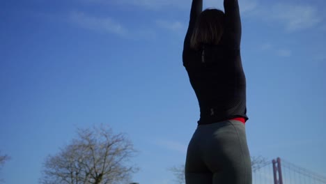 mujer joven atlética estirándose en el parque