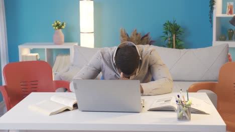 African-college-student-dancing-while-studying-at-home.