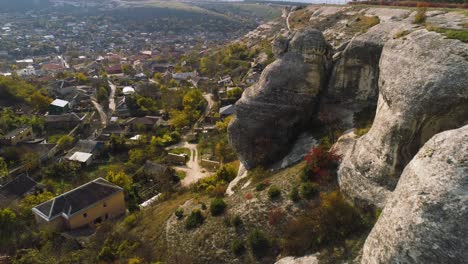 aerial view of a village nestled beside a rocky mountainside in autumn