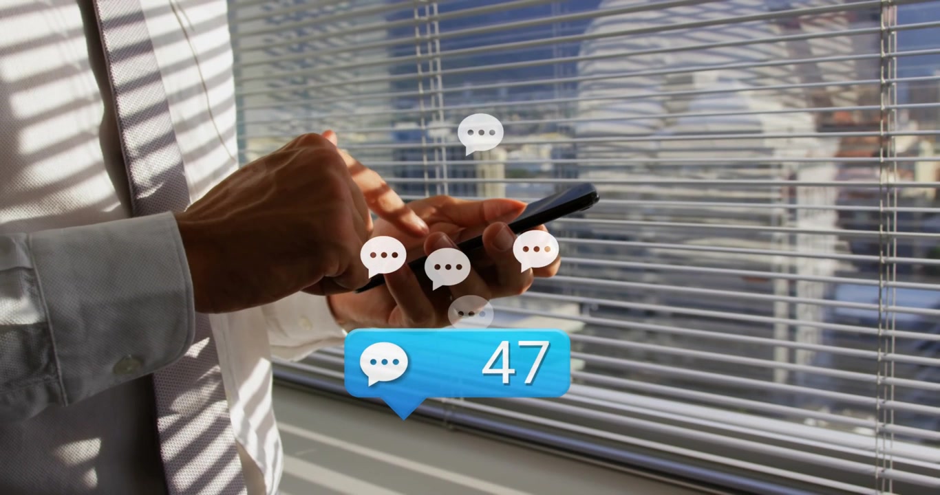 Mid-adult man tapping smartphone at blinds, generating rising chat badges around phone for business