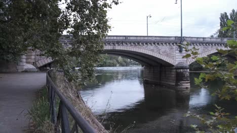 calm water on river doubs under the bridge in besancon in france, port de la republique