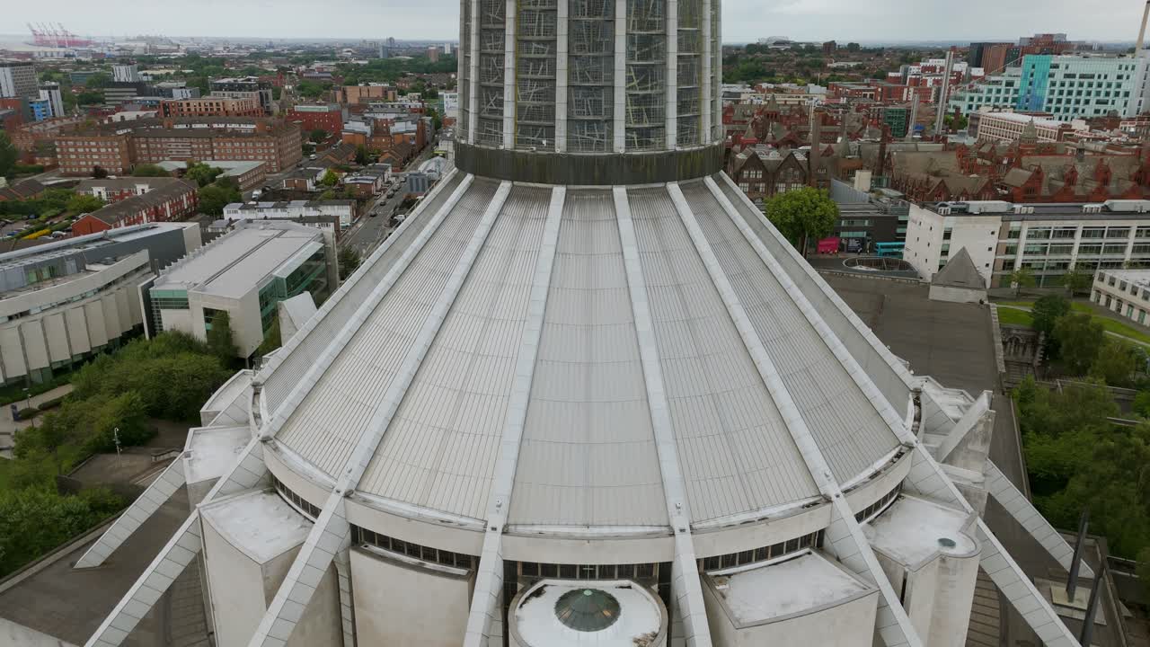 Liverpool Metropolitan Cathedral, modern architecture and surrounding cityscape, England. Aerial backward tilt-up reveal