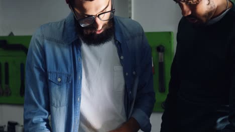 Mechanics-repairing-bicycle-in-workshop