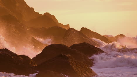 Ocean-Waves-Crashing-Against-The-Beach-Rocks-During-Sunset