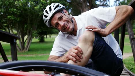ciclista caído sosteniendo su rodilla lesionada