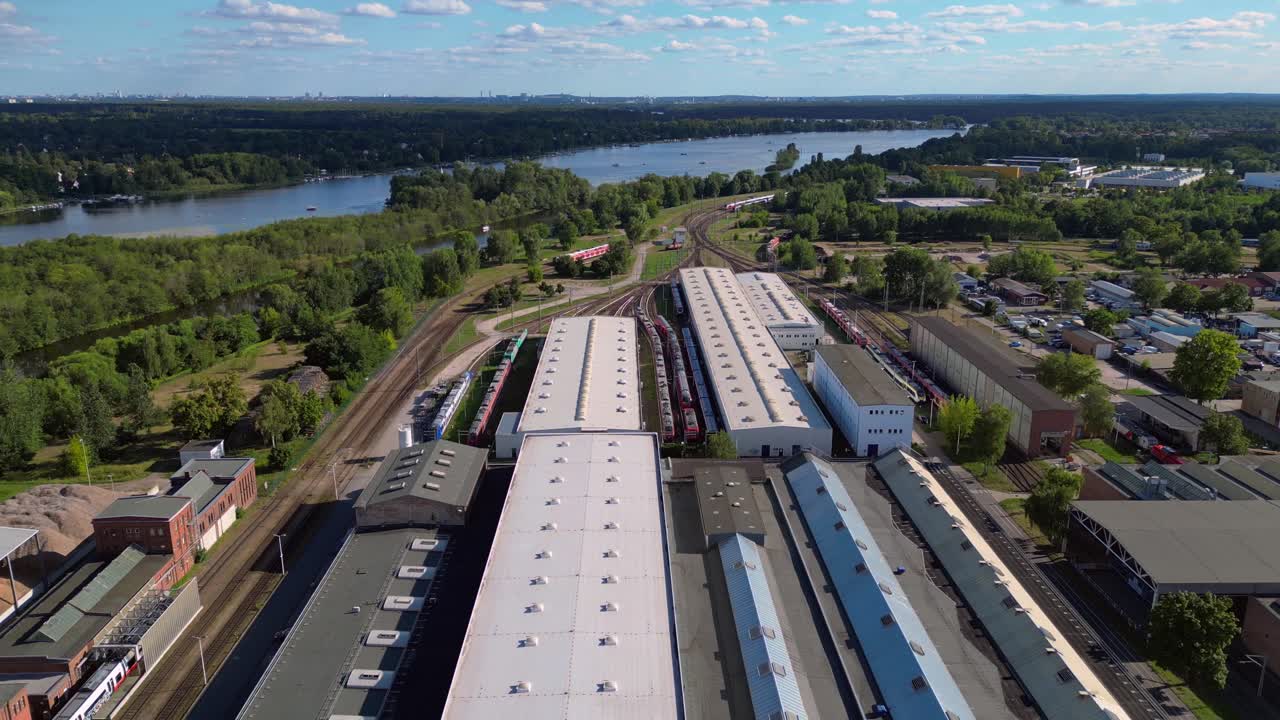 Hennigsdorf railway factory train depot overlooking the river in Brandenburg, Germany. Breathtaking aerial view flight fly reverse drone overflight flyover drone
