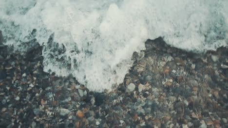 close-up shot of the sea wave hitting the stony beach