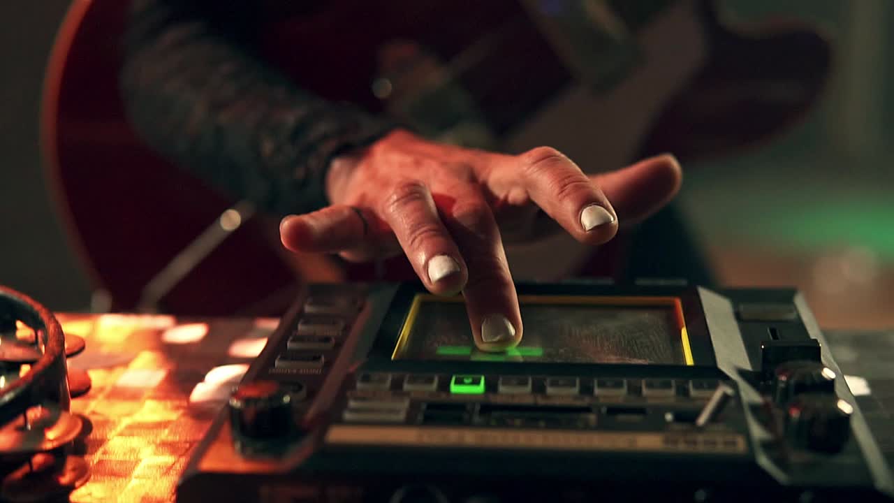 콘서트에서 연주하는 베이스 기타의 증폭기를 조정하는 사람