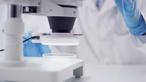un científico irreconocible usando un microscopio