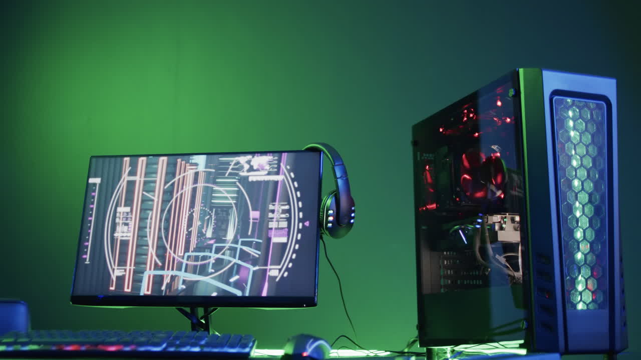 Video of gaming computer and gaming equipment on desk with copy space on neon background