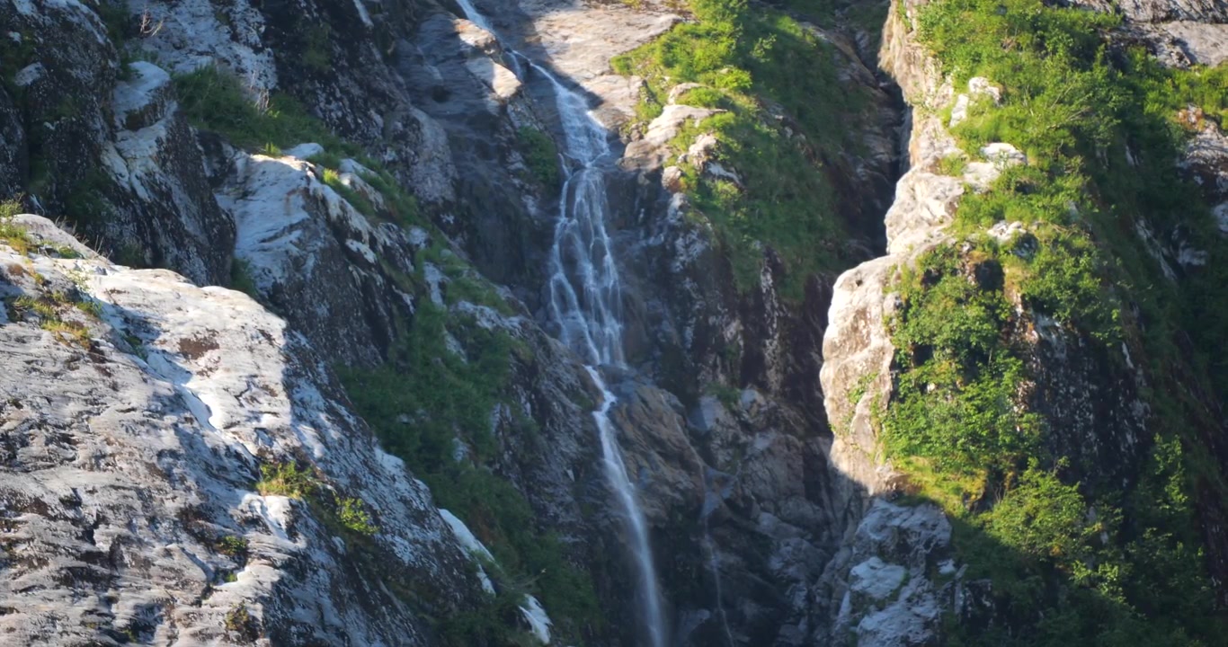 Cascata lungo la ripida parete di granito della montagna nel fiordo Endicott Arm, Ghiacciaio Dawes, Alaska