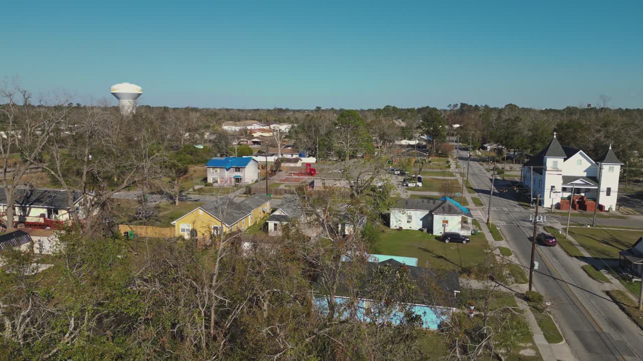 A Charming Small Town Features Colorful Houses, a Historic Church, and a Blend of Residential and Commercial Buildings - Aerial Drone Shot