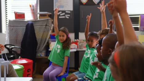 side view of mixed-race schoolkids raising their hands in the classroom 4k