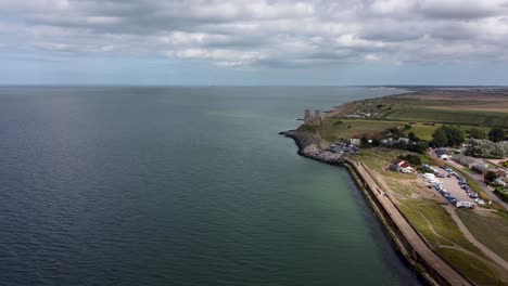 una foto de un dron de 4k de altura que muestra la línea costera reculver en kent con las históricas torres reculver