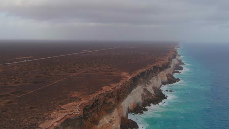 camper van driving along empty costal road, cinematic aerial wide angle shot, nullarbor, australia