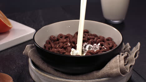 super slow motion milk is being poured into a bowl with chocolate cereal, healthy breakfast. shot with high speed camera at 420 fps