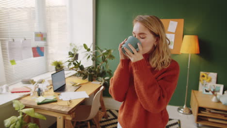 woman enjoying a drink in a home office