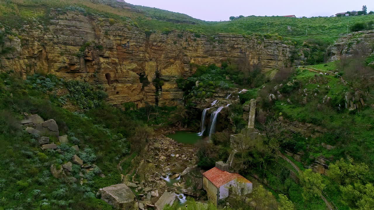vista aérea de la cascada de due rocche rodeada de pintorescas montañas en sicilia, italia