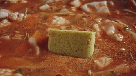 stock cube slow sinking in simmering vegetable soup