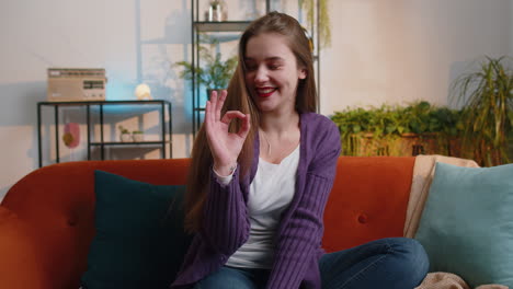 Happy-cheerful-young-woman-looking-approvingly-at-camera-showing-ok-gesture,-positive-like-sign