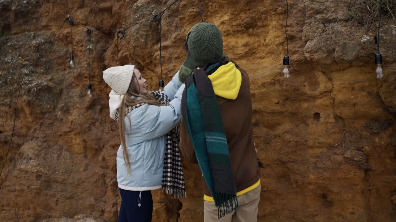 Couple Decorating String Lights on a Cliffside in Winter