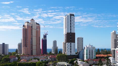 high-rise buildings under construction in gold coast, australia, captured in a time-lapse sequence with clear blue skies
