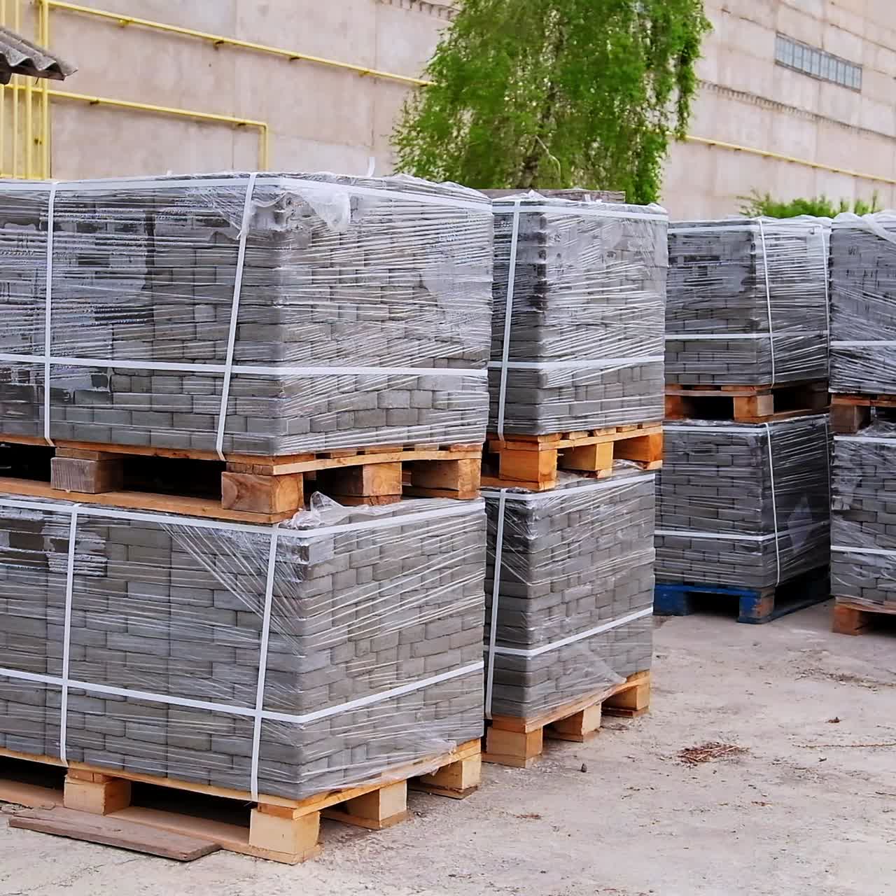 Large packs of grey bricks left outside at the construction zone. Site prepared for a new building with materials for it