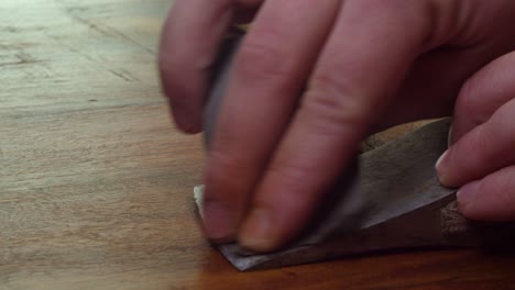 de cerca: papel de arena de grano fino se utiliza para limpiar la óxido de la cabeza del hacha vieja