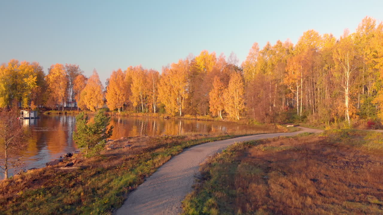 moviéndose por un sendero en un paisaje sereno en un colorido día de octubre cerca de un hermoso lago