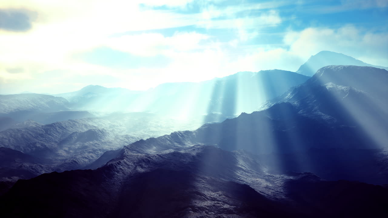 Dramatic sunlight beams illuminating mountain landscape at dawn