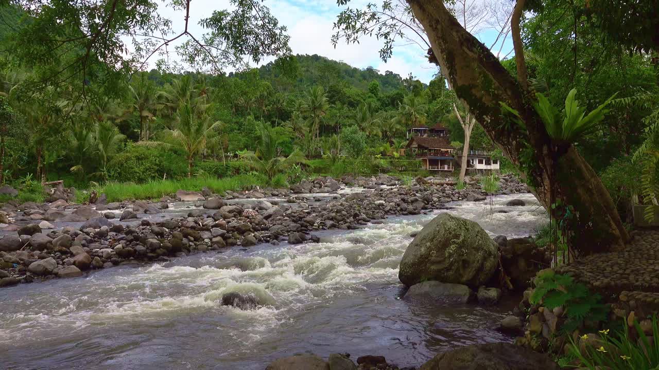 villas balinesas tradicionales con vistas a un arroyo que fluye después del reciente monzón