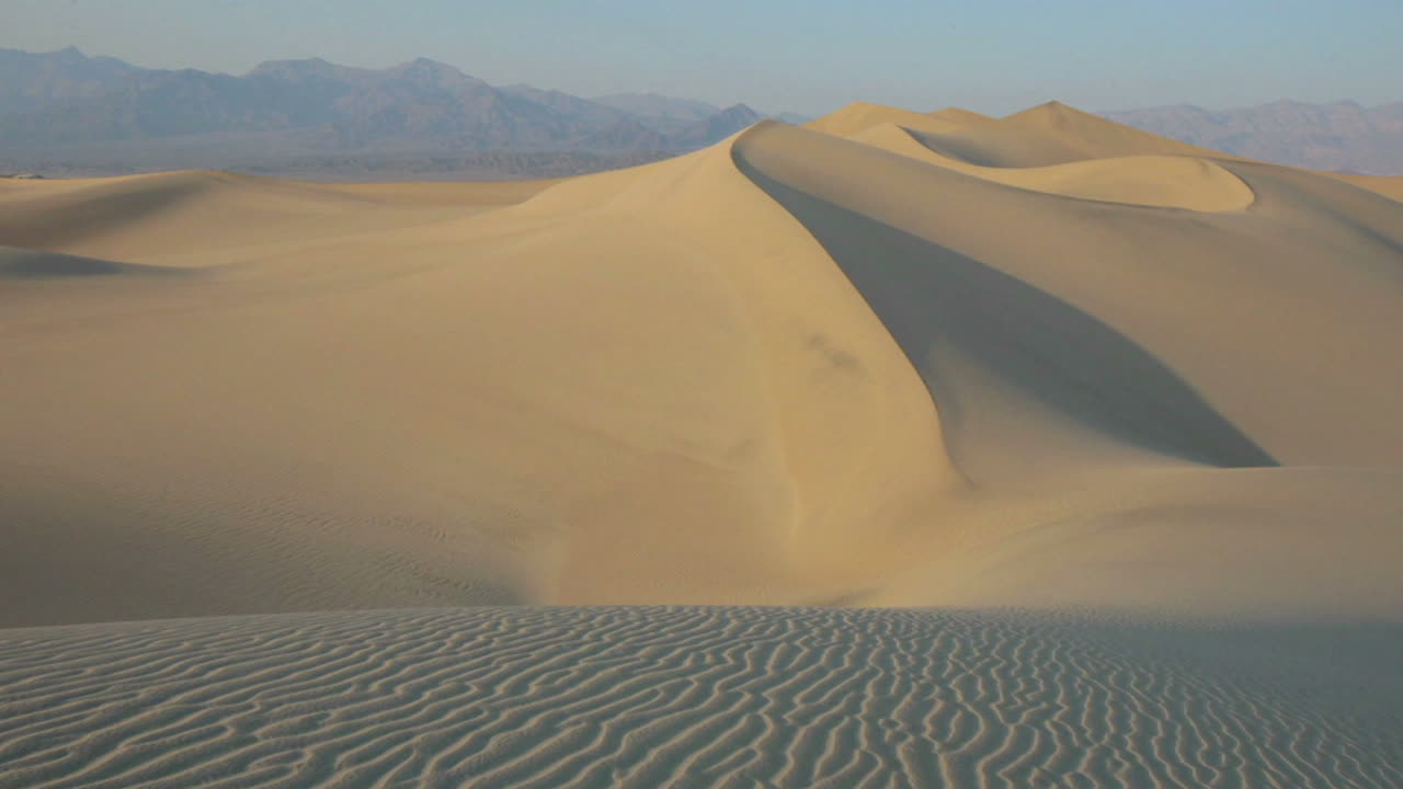 las sombras se mueven sobre una duna de arena