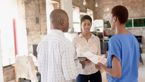 Happy-african-american-colleagues-using-tablet-and-discussing-work-in-office,-slow-motion