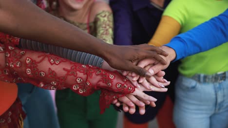 jóvenes diversos celebrando juntos apilando las manos al aire libre