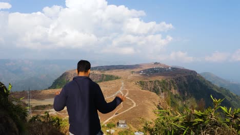 Joven-Disfrutando-De-La-Vista-Natural-Prístina-Por-La-Mañana-Desde-Un-ángulo-Plano