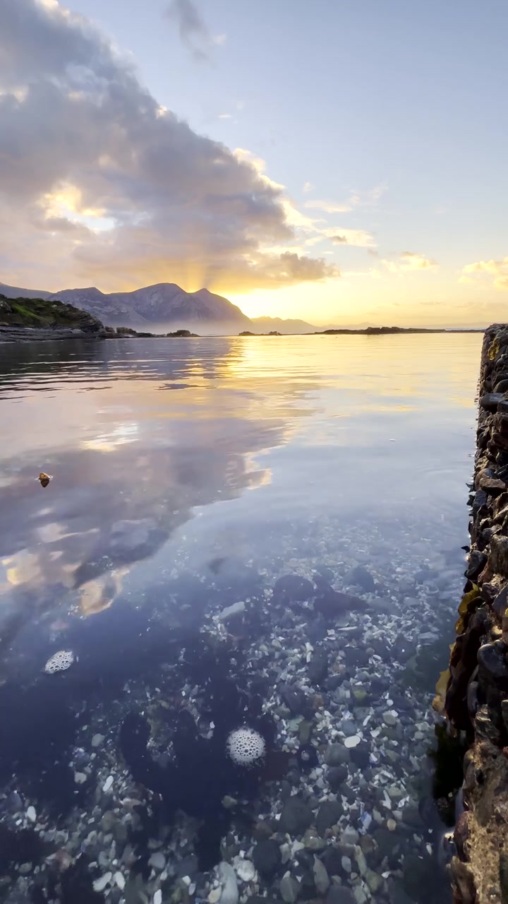 Hermanus'taki kıyı deniz havuzunda canlı gün doğumu yansıması. Dikey